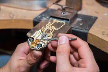 Kuyumcu mücevher altın ürün üzerinde giderir.