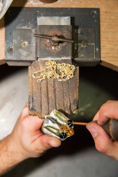 Juwelier bevestigt edelstenen op gouden product — Stockfoto