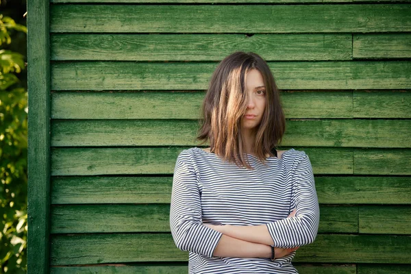 Chica cerca de pared de madera verde —  Fotos de Stock