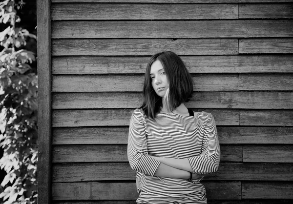 Belle fille près du mur en bois — Photo