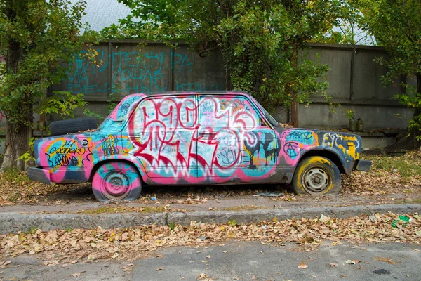 Straatkunst graffiti op een verlaten auto — Stockfoto