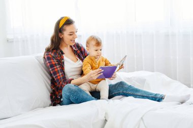 Bir anne ve oğlunun portresi kitap okuyor ve evde birlikte eğleniyorlar.