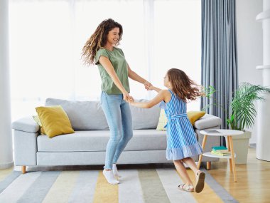 Anne kız dans ediyor ve evde eğleniyorlar.