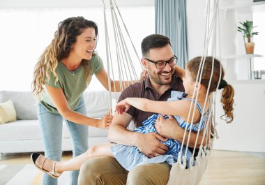 Aile evde salıncakta sallanırken eğleniyor.