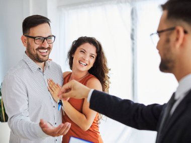 Anahtarları alan mutlu genç çift yeni bir ev alıyor. 