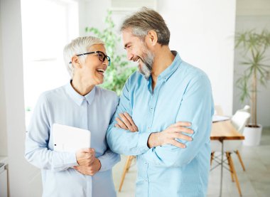 Kıdemli iş adamı kadın ofisi mutlu takım arkadaşı takım çalışması gülümsüyor.