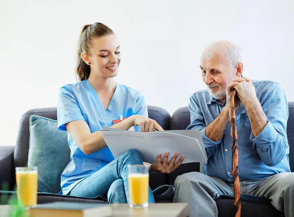 Enfermero médico cuidado de personas mayores folleto mostrando cuidador ayuda asistencia retiro casa enfermería anciano hombre —  Fotos de Stock