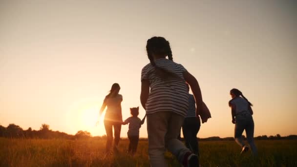 glückliche Familienkinder laufen gemeinsam im Park bei Sonnenuntergang. Menschen im Parkkonzept. glückliche Familie freudigen Lauf. glückliche Familie und kleines Baby Kind Sommer Kind Traum Konzept Spaß