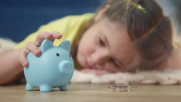 girl kid child puts coins save in a piggy bank pig. economy finance crisis coronavirus fund concept. little girl save money puts coins in a piggy bank. rich kid business planning