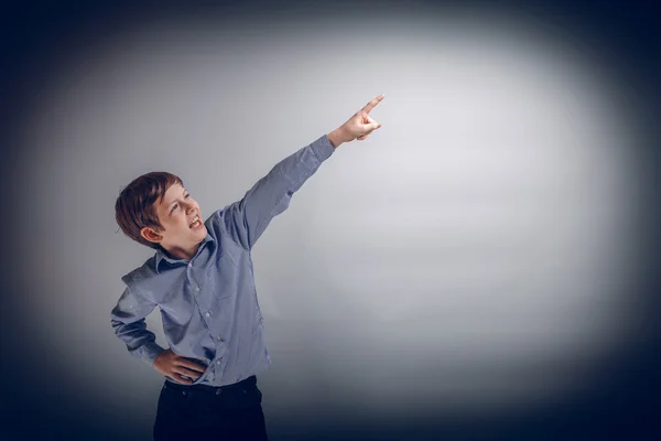 Boy teenager of European appearance indicates his hand up on a g — Stock Photo, Image
