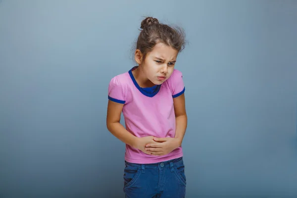 Ragazza bambino dolore addominale su uno sfondo grigio — Foto Stock