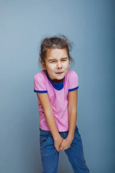 Girl child wants to use the toilet on a gray background — Stock Photo, Image