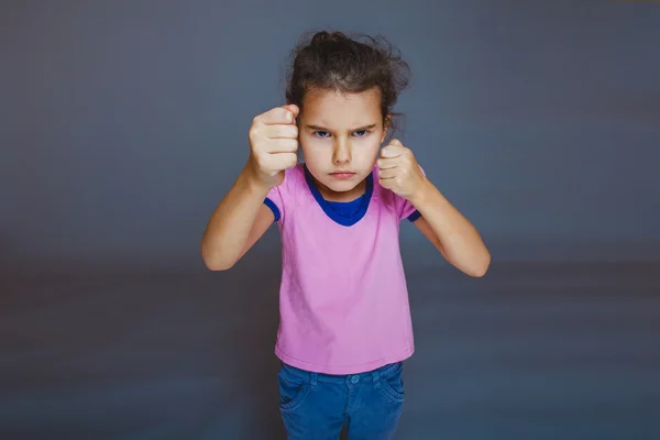 Girl clenched her fists on a gray background — Stock Photo, Image