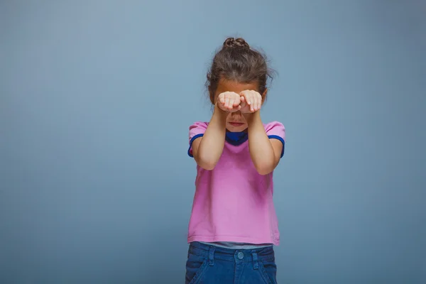 Ragazza ha chiuso gli occhi mani su uno sfondo grigio — Foto Stock