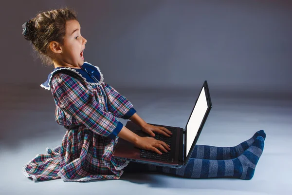 Mädchen, das auf einen Computer blickt, erlebt lebhafte Emotionen — Stockfoto