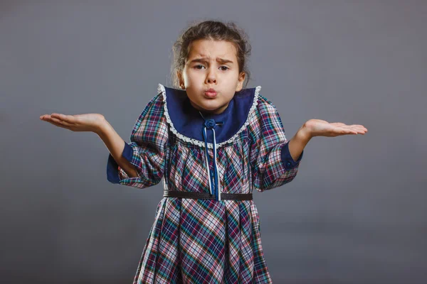 Girl spread her hands in disbelief on gray background — Stock Photo, Image