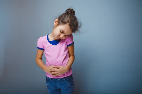 Menina winced em dor segurando suas mãos sobre o estômago — Fotografia de Stock