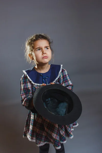 Flicka med hatt i handen ber mynt grå — Stockfoto