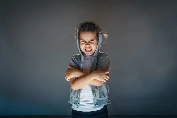 Bambina arrabbiata su uno sfondo grigio arte — Foto Stock