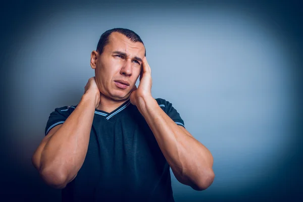 Mannetje van Europees uiterlijk brunet bezit is van zijn hand over hea — Stockfoto