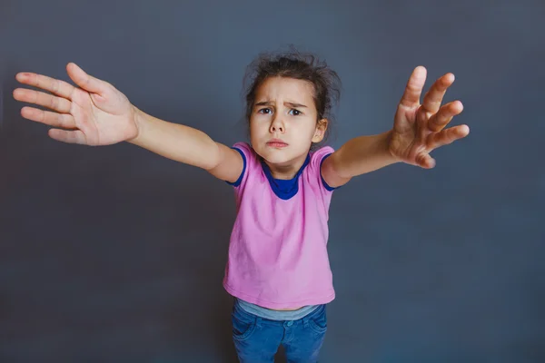 Niña triste mirando la cámara tira de las manos —  Fotos de Stock