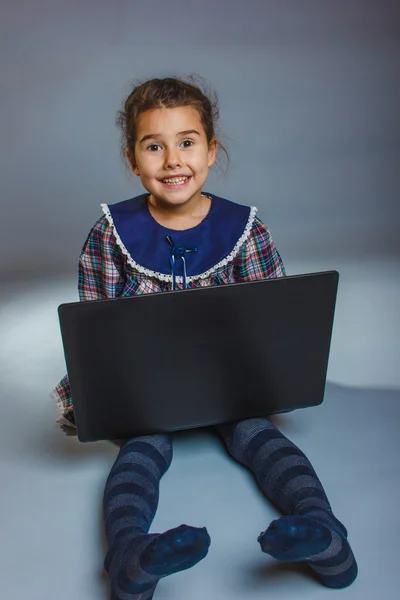 Teen girl 5 years of European appearance plays a laptop — Stock Photo, Image