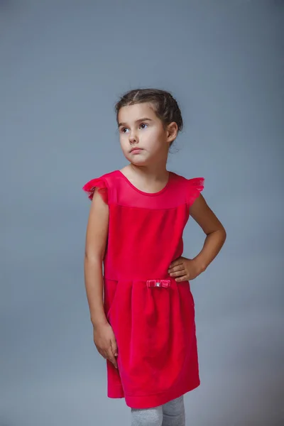 Tini lány elgondolkozva néz a távolba, piros ruhás — Stock Fotó