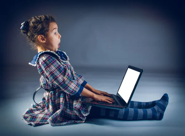 Tiener meisje, zittend op de vloer spelen laptop verbaasd — Stockfoto