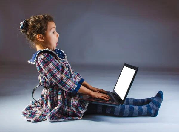 Teen girl sitting on the floor playing laptop surprised — Stock Photo, Image
