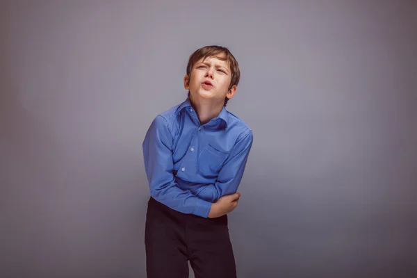 Adolescente menino dor abdominal no fundo cinza — Fotografia de Stock