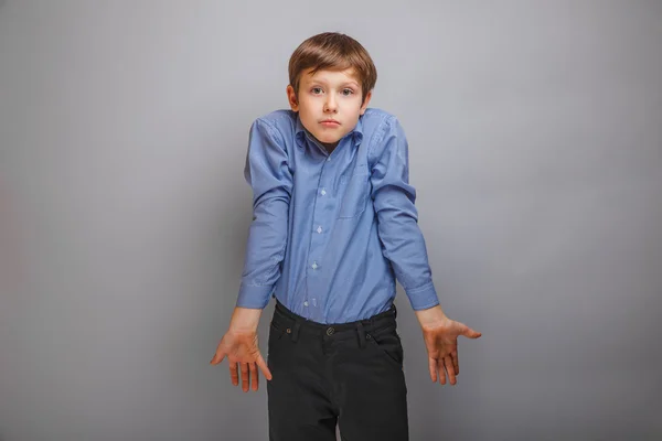 Teenager boy in a shirt shrugs — Stock Photo, Image