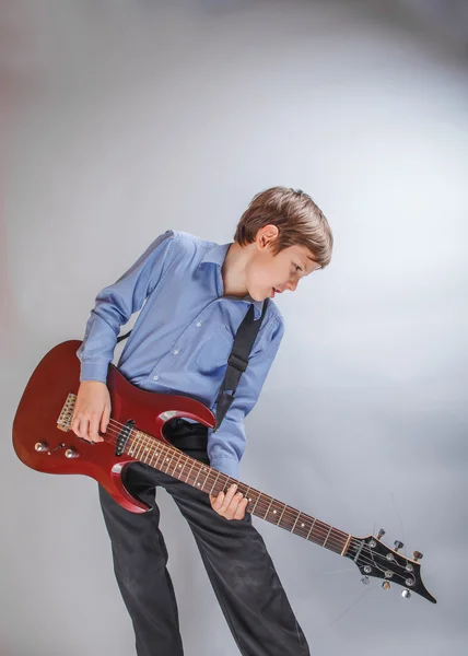 Teenager boy of 10 years European appearance playing guitar o — Stock Photo, Image