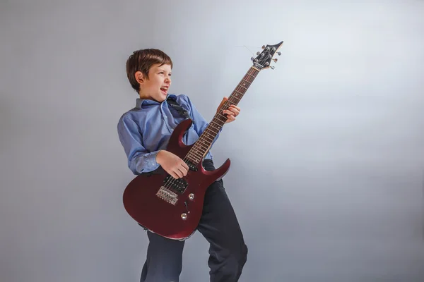 Boy adolescence European appearance enthusiastically playing gui — Stock Photo, Image