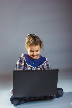 dizüstü sürpriz gri arka plan üzerinde oynayan kız bebek