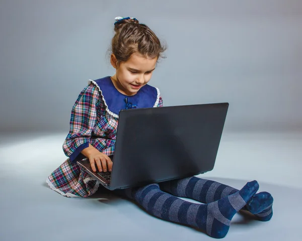 Teen flicka spelar 5 år med europeiskt utseende laptop sitter på — Stockfoto