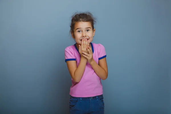 Adolescente niña es feliz sorpresa sobre fondo gris — Foto de Stock