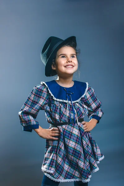 Adolescente ragazza bambino in un abito scozzese e mens cappello guardando al si — Foto Stock