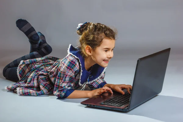 Babymeisje op zoek computer en glimlachen — Stockfoto