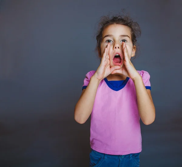 Teen girl opened her mouth is calling on gray background — Stock Photo, Image