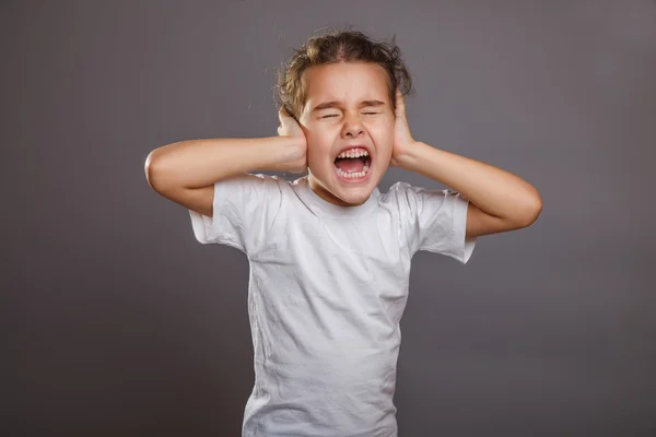 Teen girl screams closes ears gray background — Stock Photo, Image