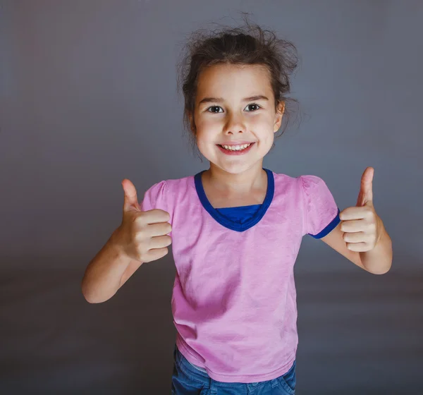 Teenie-Mädchen zeigt Geste Ja auf grauem Hintergrund — Stockfoto