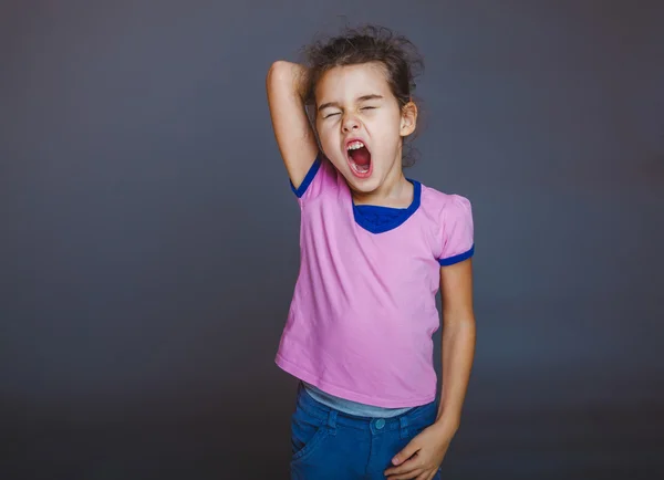 Teen girl yawns sleepy opened her mouth on gray background — Stock Photo, Image