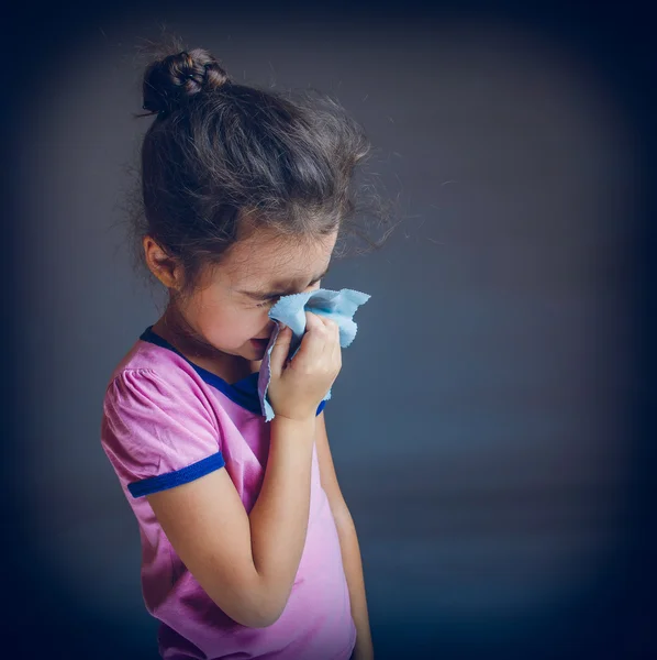 Teenage girl suffers runny nose sneezing handkerchief on a gray — Stock Photo, Image