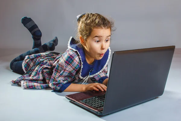 Teenager-Mädchen schaut auf Computer und wundert sich — Stockfoto