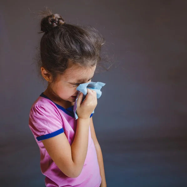 Teenage girl suffers runny nose sneezing handkerchief on a gray — Stock Photo, Image