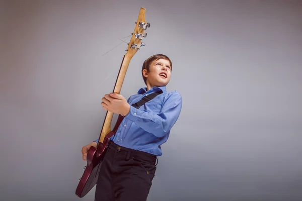 Teenager ein Junge braun europäisches Aussehen spielt Gitarre — Stockfoto