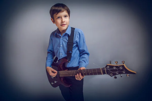 Adolescente ragazzo capelli castani di aspetto europeo suonare la chitarra ex — Foto Stock