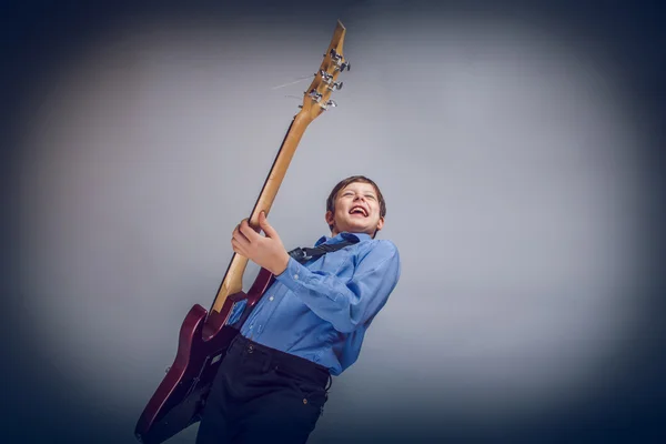 Teenager Junge braune Haare von europäischem Aussehen spielt Gitarre fe — Stockfoto