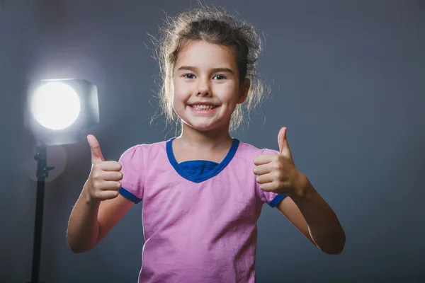 Bambina mostrando gesto sì su sfondo grigio — Foto Stock