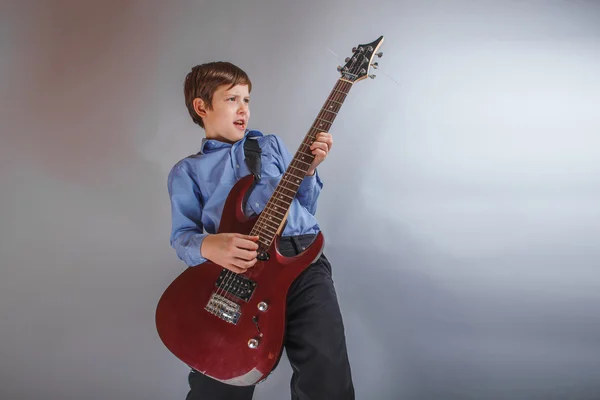 Adolescente un chico oscuro marrón europeo apariencia jugando guitarra feliz — Foto de Stock